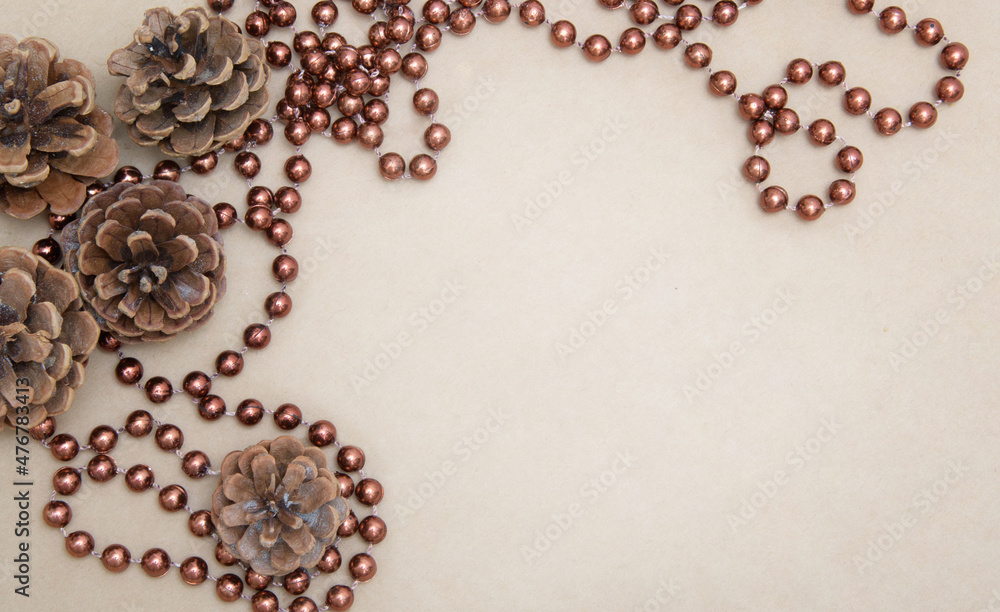 New Year card. Cones and brown beads on a parchment background. Craft paper. Abstract image. New Year card. Cones and brown beads on a parchment background. Craft paper. Abstract image.