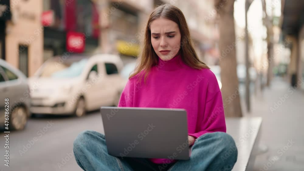 Young blonde woman with winner expression using laptop at street Young blonde woman with winner expression using laptop at street