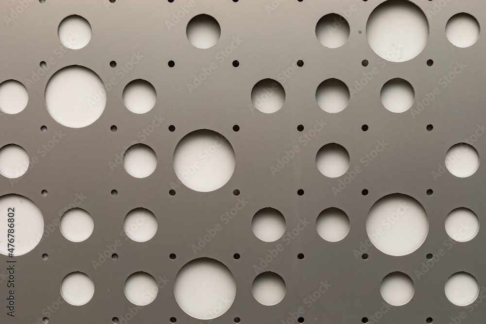 Round hole tiles. Metal cladding of the building facade