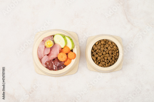 A bowl of dry food and a bowl of natural pet food. Choice of food for dogs and cats. View from above.