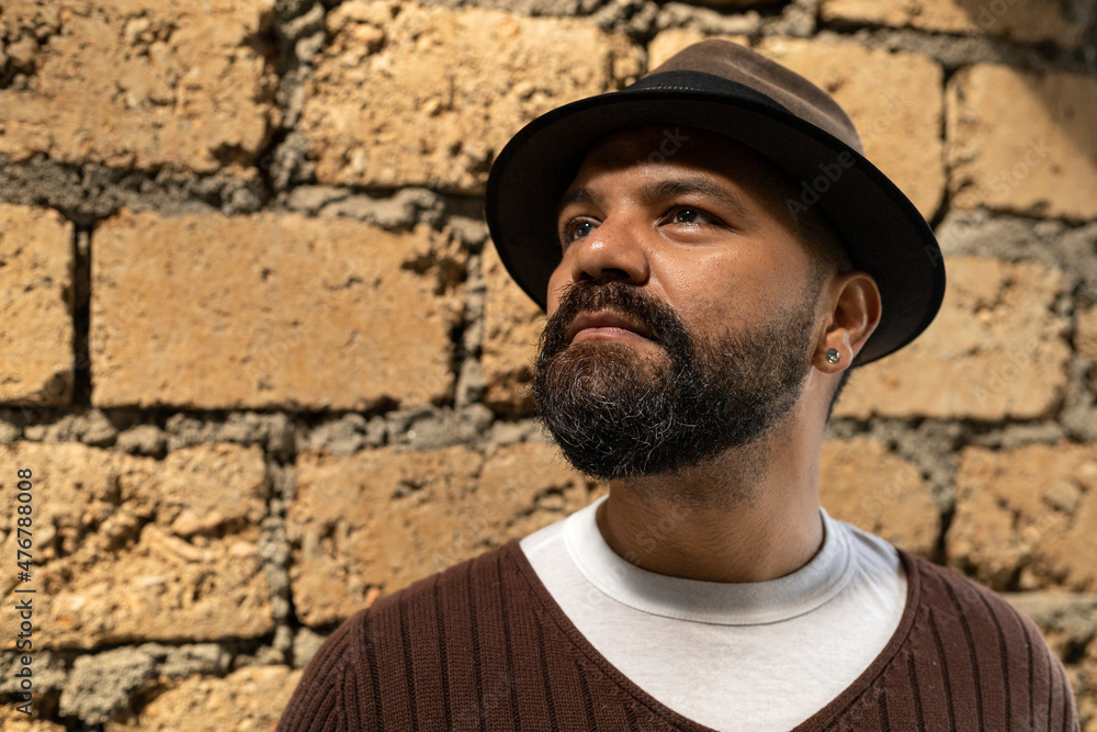 Latino man (39) in brown hat and sweater, looks at his phone while making a nonconforming gesture with his eyes. Lifestyle concept. Latino man (39) in brown hat and sweater, looks at his phone while making a nonconforming gesture with his eyes. Lifestyle concept.