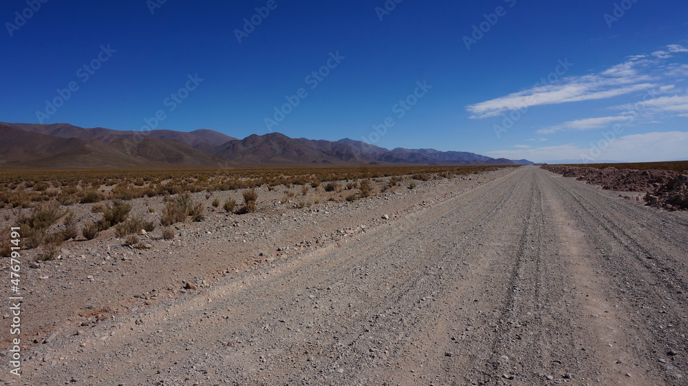 very long straight gravel road in the andes south america