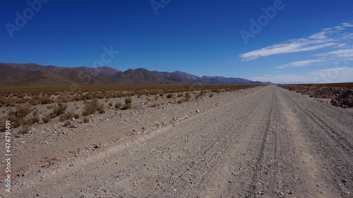 very long straight gravel road in the andes south america
