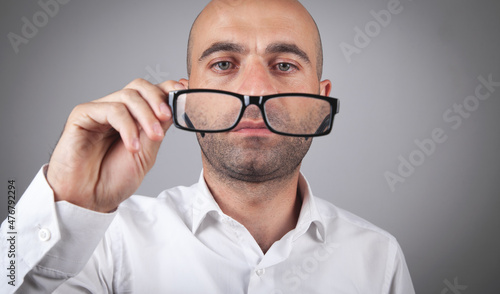 Man holding eyeglasses in office.