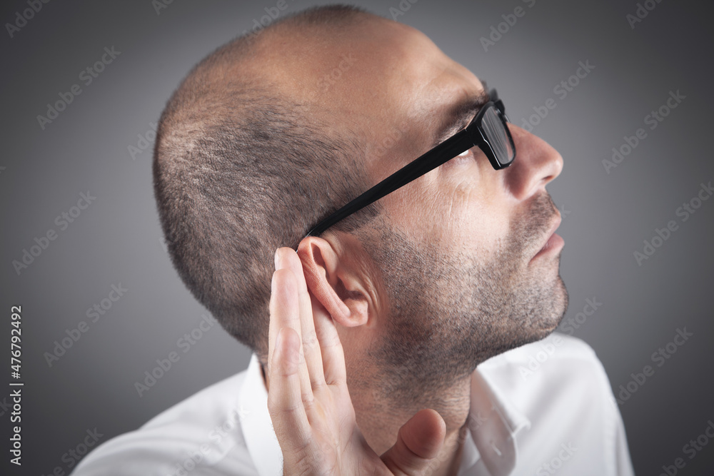 Caucasian man hold hand near ear. Trying to hear a gossip Caucasian man hold hand near ear. Trying to hear a gossip
