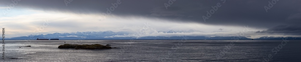 Panoramic View of Rocky Shore on the West Pacific Ocean Coast during cloudy winter evening. Taken at Saxe Point Park, Victoria, Vancouver Island, British Columbia, Canada.
