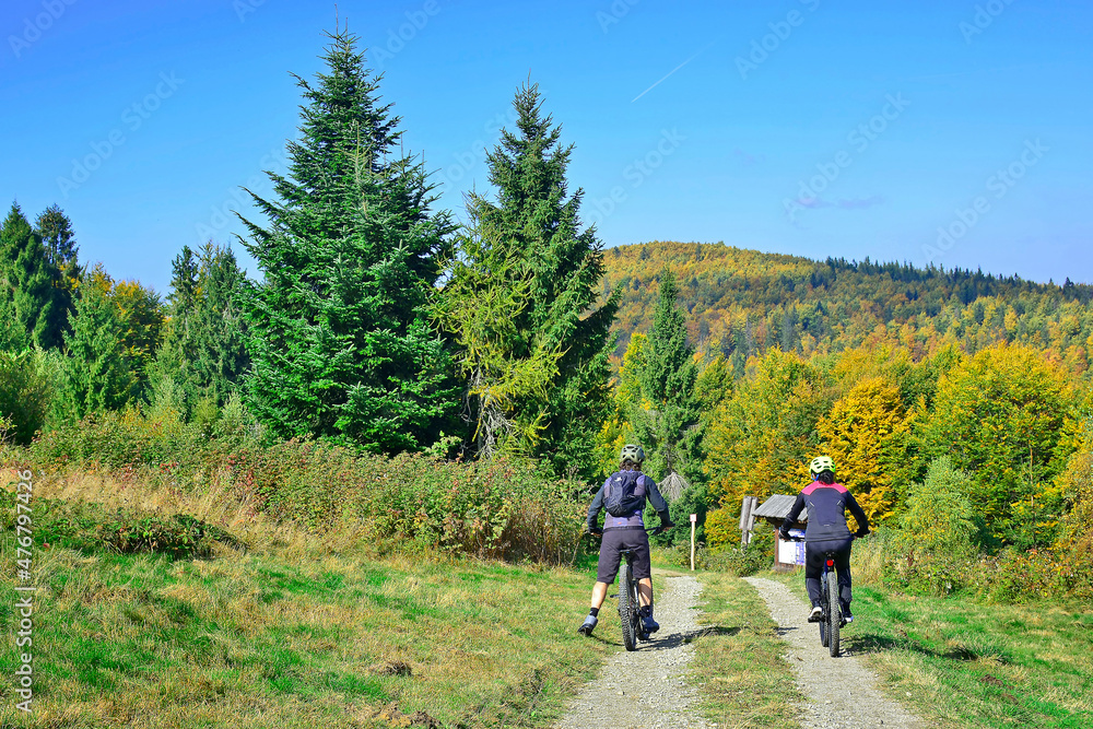 Couple bikers ride on the mountains path in autumn sunny day.  Natural Light.