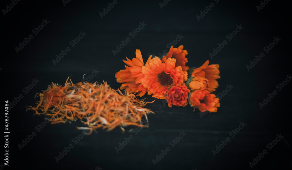 bright fresh flowers and dried flowers of calendula h in a black wooden background
