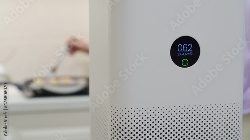 White smart air purifier with digital display showing humidity, temperature and degree of air pollution. Capture and eliminate smoke, dust, pollen at home. High quality 4k footage