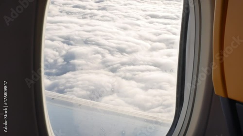 Flight from WROCLAW, POLAND to BELGIUM, BRUSSELS - JANUARY 11, 2018: View from airplane window on clouds lit by the sun. 4K, Handheld