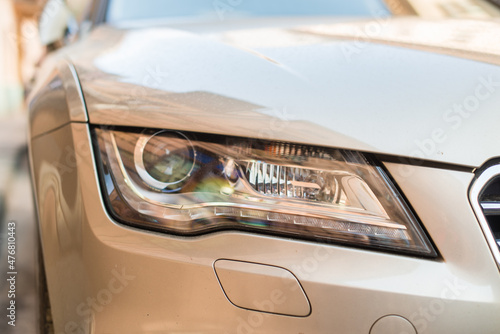 Close up view of the car standing at the city street. One had light of automobile parked on the street. Stock photo photo