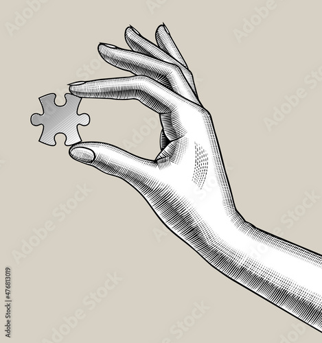 Female hand holds a puzzle in her fingers. Vintage engraving stylized drawing