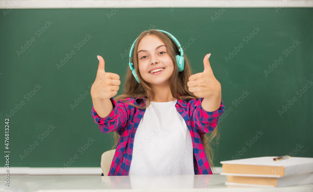 happy kid with earphones at blackboard showing thumb up, ebook happy kid with earphones at blackboard showing thumb up, ebook
