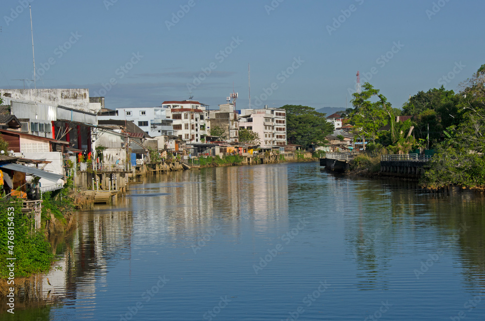 Obraz premium White building and trees with reflection in the water