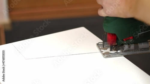 Wallpaper Mural A man cuts a window sill from a board for a window using an electric jigsaw for work. Torontodigital.ca