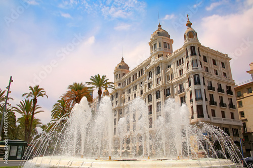 Beautiful water fountain along the waterfront of the city with historic traditonal buildings, Explanada de Espana lined with palm trees, Spain.