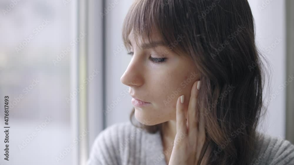 Pensive young female with leukodermia sitting by window, upset with troubles Pensive young female with leukodermia sitting by window, upset with troubles