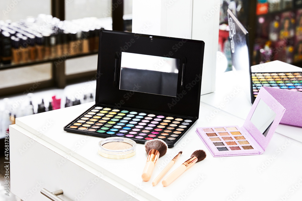 Palette of shadows, brushes and professional makeup on table with vanity lighting. Horizontal photo. Palette of shadows, brushes and professional makeup on table with vanity lighting. Horizontal photo.