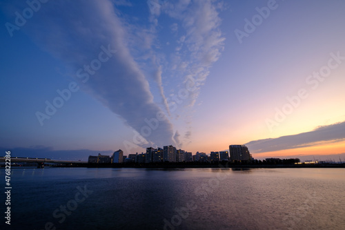 Foto 夜明け前の都市景観。太陽が昇前のマジックアワー。あたりがオレンジ色に染まる。兵庫県芦屋浜より西宮浜を臨む