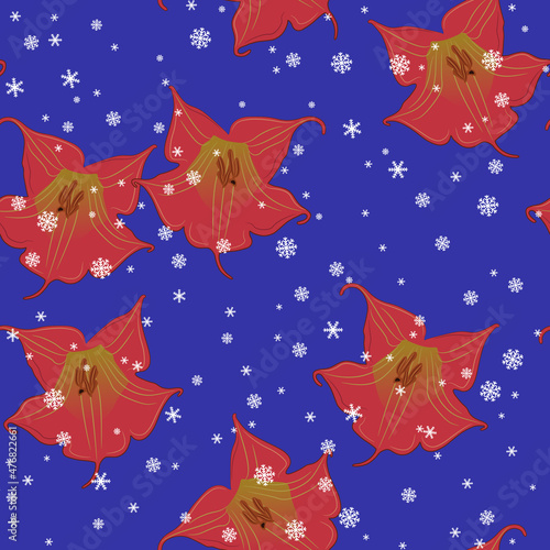 Seamless floral pattern with flowers of red datura and snowflakes. Brugmansia sanguinea. On blue background. Seasonal winter design.