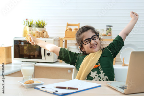 Foto Indian student girl get tiring and bored from online study at home, stretching h