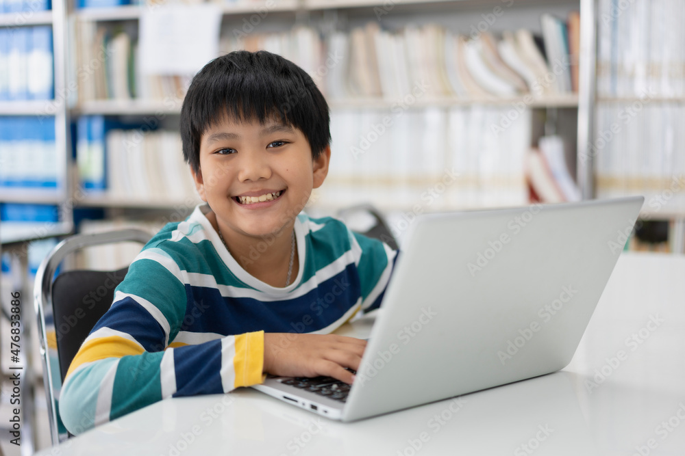 Portrait of Cute Asian boy studying or playing game with laptop computer Portrait of Cute Asian boy studying or playing game with laptop computer