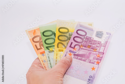 Close-up of euro banknotes in hand on a white
