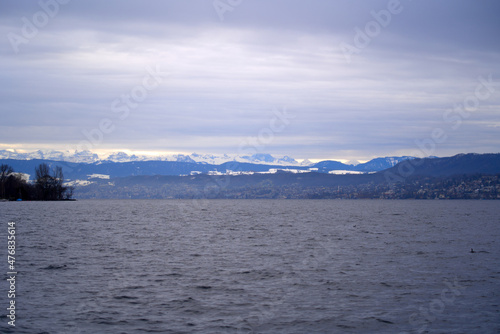 View over Lake Zurich with Swiss Alps in the background on a rainy winter day. Photo taken December 24th, 2021, Zurich, Switzerland.