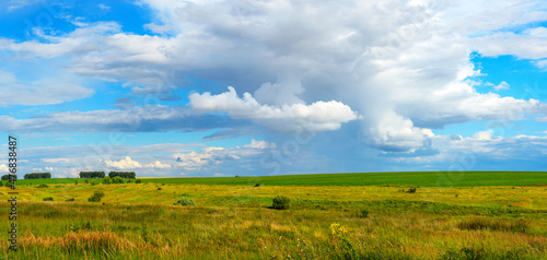 Summer rural panoramic landscape with green fields and hills.