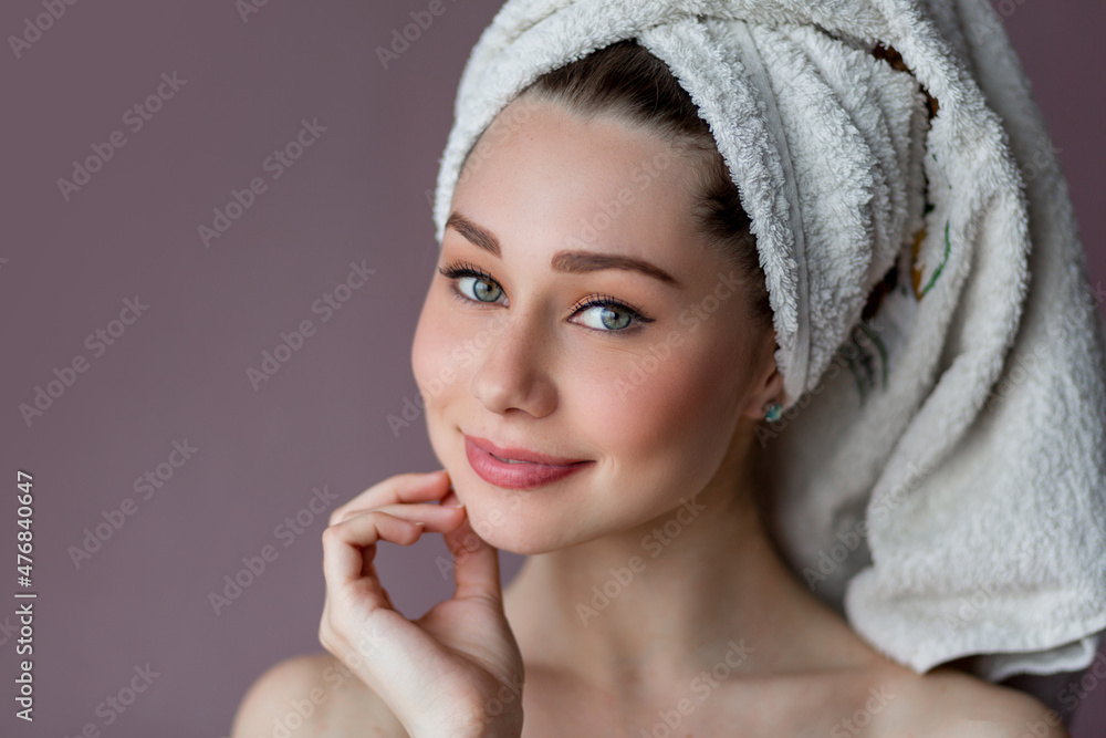 Arttractive smiling young woman wearing bathrobe and towel over her head standing over pink background purple background. Arttractive smiling young woman wearing bathrobe and towel over her head standing over pink background purple background.