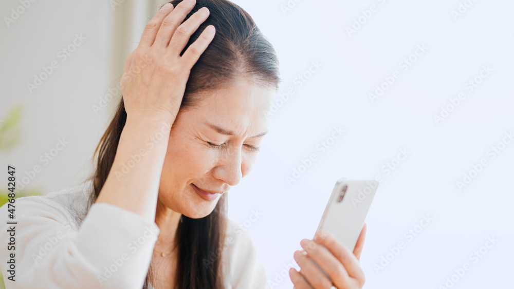 スマートフォンを使うシニア女性 スマートフォンを使うシニア女性