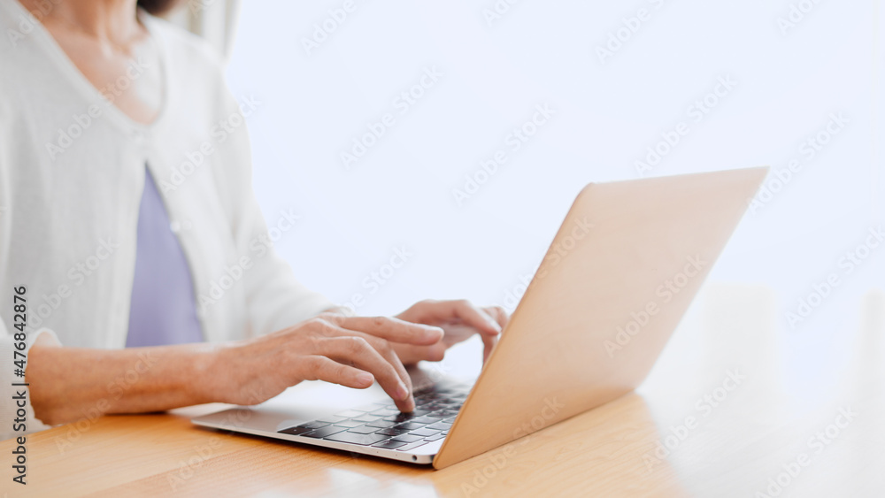 Fototapeta premium ノートパソコンを使うシニア女性