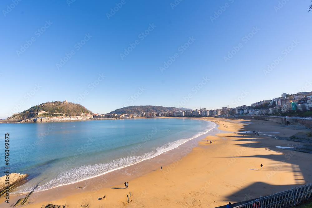 People walking on La Cocha beach in the city of San Sebastian one sunny morning, Gipuzkoa. Basque Country