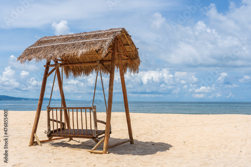Wooden swing under a thatched roof on a sandy tropical beach near the sea on the island of Phu Quoc  Vietnam