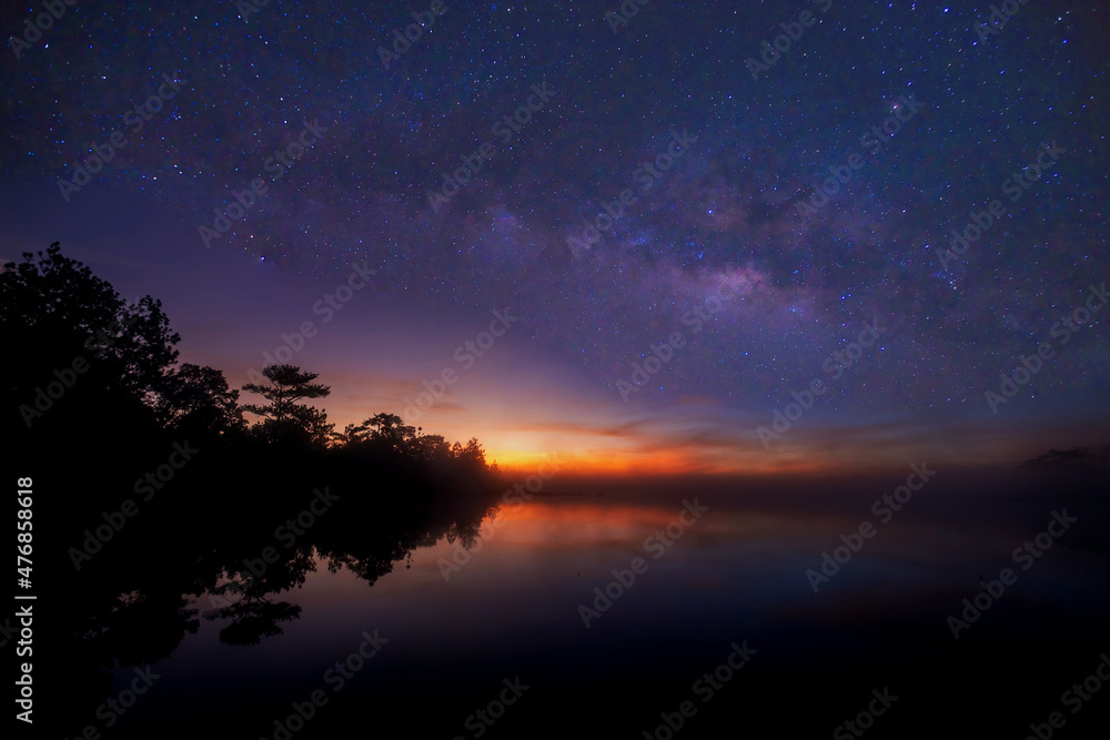 Beautiful milky way on the reservoir and the pine forest