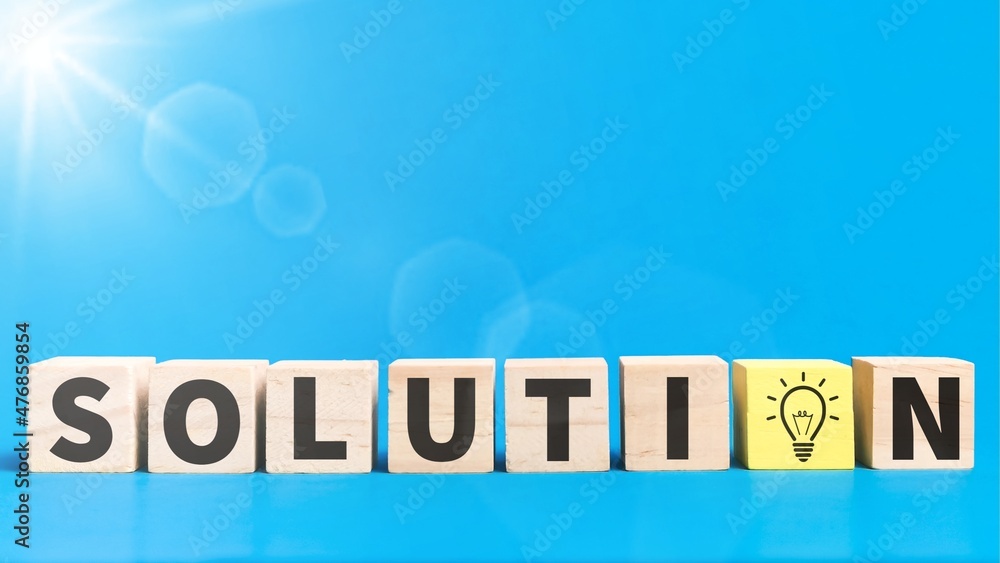 Text solution on wooden cubes against blue background.