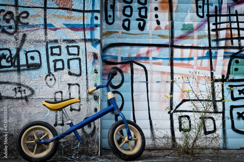 Laufrad lehnt an einer Grafitti-Wand photo