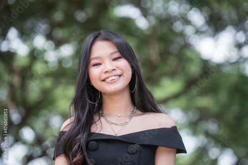 A pretty young asian teenager with overbite. A darling teen in a cute black dress. photo