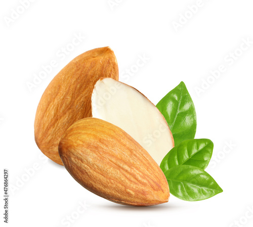 Tasty almonds and fresh green leaves on white background
