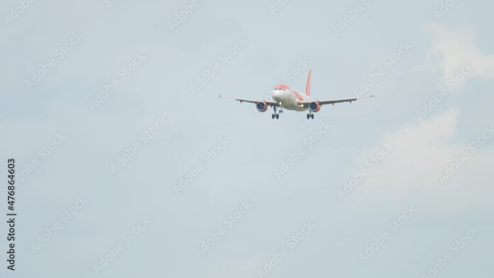 Civil jet airplane approaching landing, long shot. Airliner silhouette in dark cloudy sky at dusk Civil jet airplane approaching landing, long shot. Airliner silhouette in dark cloudy sky at dusk