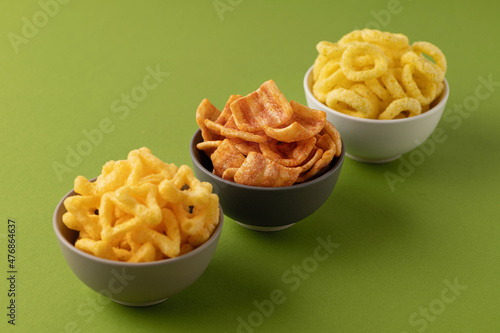 snacks, with bacon, onion rings, cheese snacks, snack set, on a green background in ceramic bowls