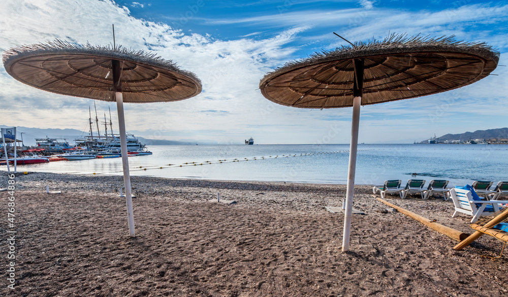Sunshades or umbrellas on central beach of Eilat - famous tourist resort and recreational city in Israel Sunshades or umbrellas on central beach of Eilat - famous tourist resort and recreational city in Israel