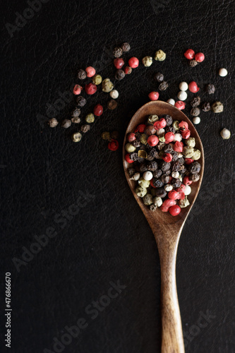 red white and black peppercorns seasoning on black background