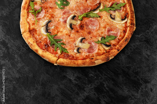 Tasty pizza on black concrete background. Top view of hot pizza. With copy space for text. Flat lay. Banner.