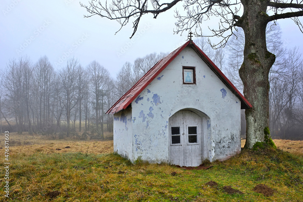 Old small chapel under tree in foggy autumn day, Blechnarka, Beskid Niski, Poland Old small chapel under tree in foggy autumn day, Blechnarka, Beskid Niski, Poland