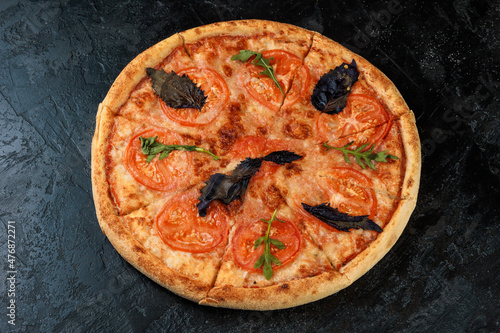 Tasty pizza on black concrete background. Top view of hot pizza. 