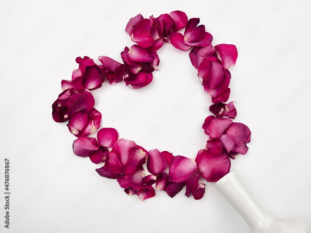 Obraz premium Heart-shaped rose petals spilled from a fallen vase, Valentines card