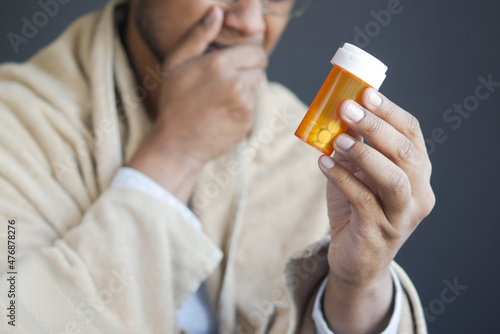 sad young man hand holding medicine pill container 