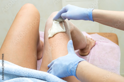 Fotografie, Obraz Hair removal leg with sugar paste in a beauty salon