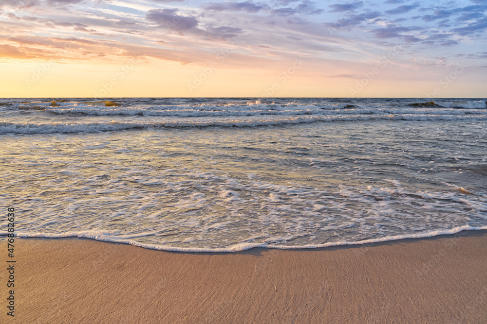 Sunset on Baltic Sea white pastel color sky and rough sea.
